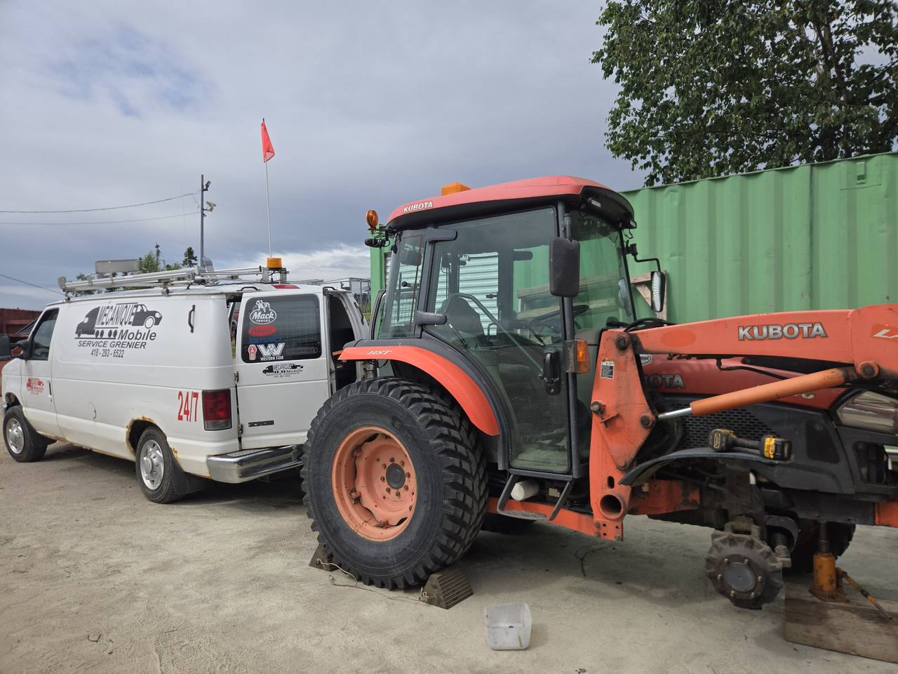 Tracteur Kubota en réparation à côté de la fourgonnette de service